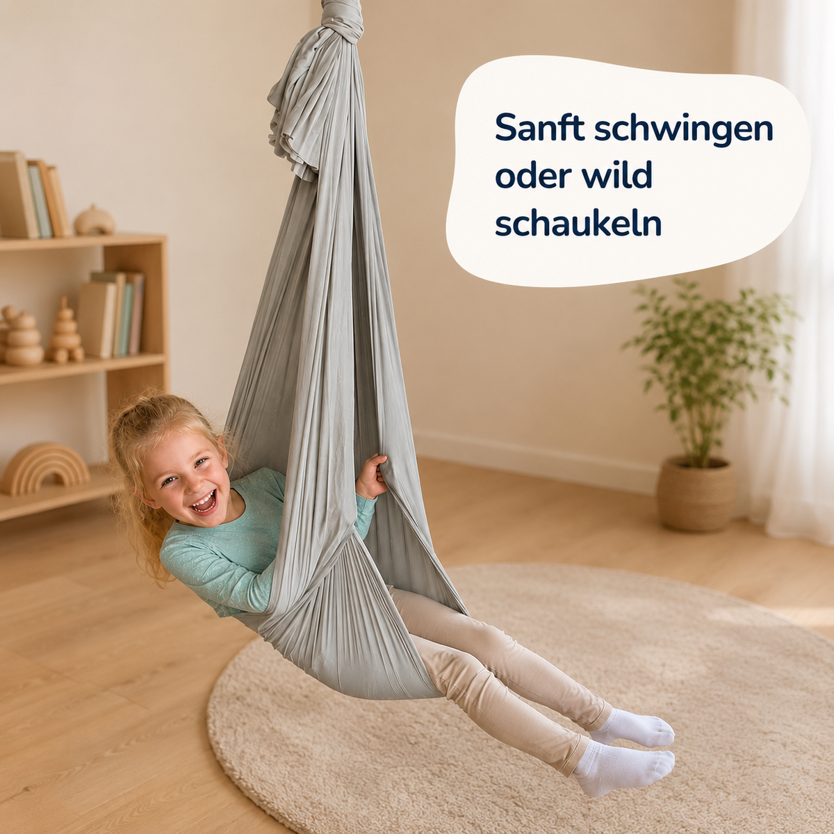Mädchen schwingt lachend im hellgrauen Tuch, Kinderzimmer mit Regal, daneben der Hinweis: Sanft schwingen oder wild schaukeln