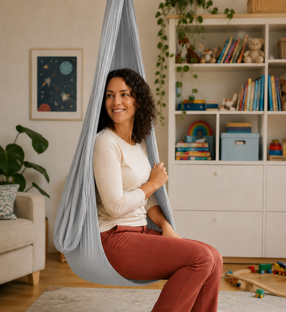 Erwachsene sitzt im hellgrauen Tuch, Kinderzimmer mit Regal