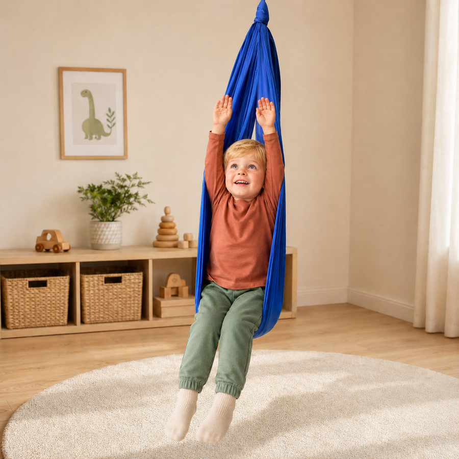 Junge steht im royalblauen Tuch und streckt die Arme nach oben, Kinderzimmer mit Regal